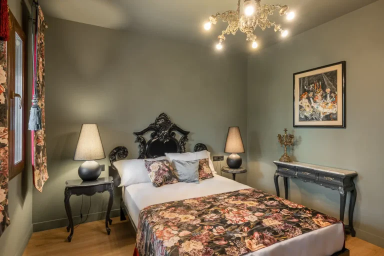 dormitorio elegante con cabecero negro tallado y ropa de cama floral