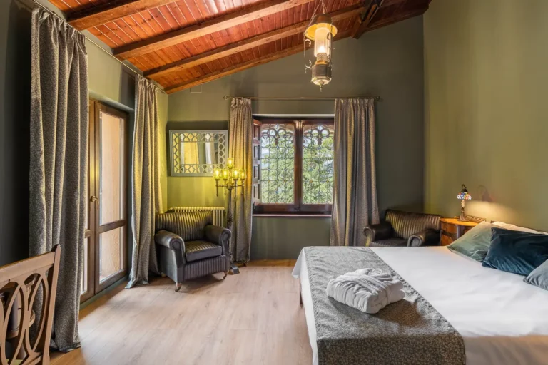 dormitorio rustico con techo de madera sillones de cuero y ventana