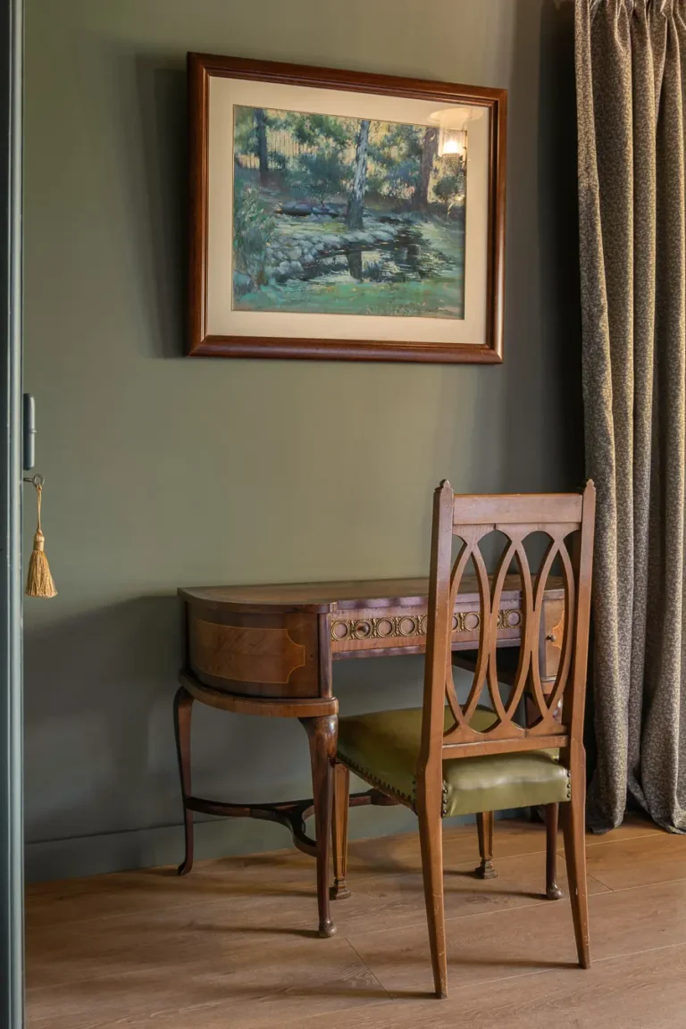 escritorio antiguo de madera con silla y cuadro de paisaje
