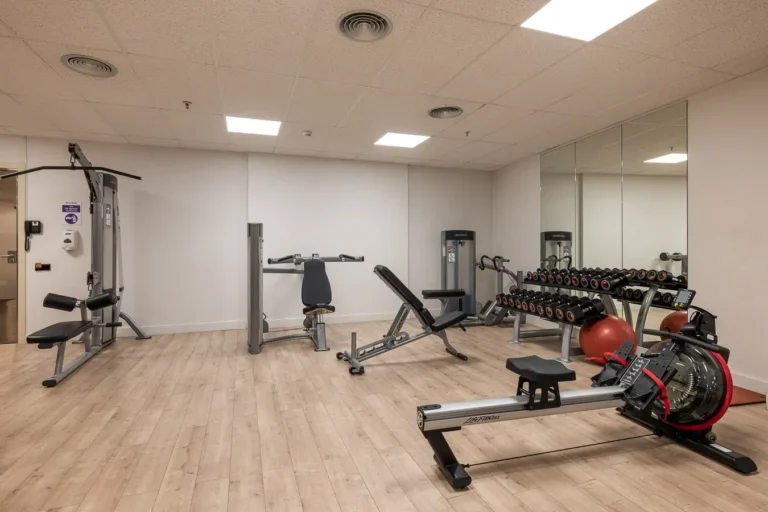 gimnasio de hotel con pesas y maquinas de entrenamiento