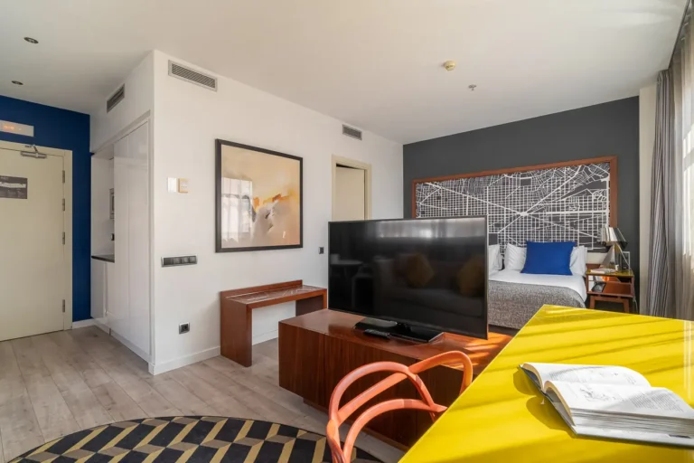 habitacion de hotel con televisor escritorio y cama