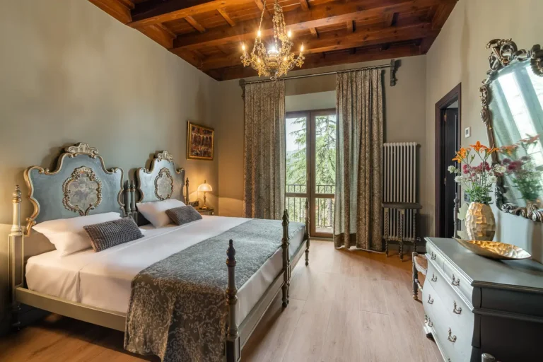 habitacion elegante con cama de cabeceros ornamentados y lampara de arana