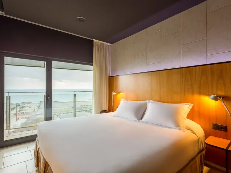 habitacion hotel con cama doble y vistas al mar