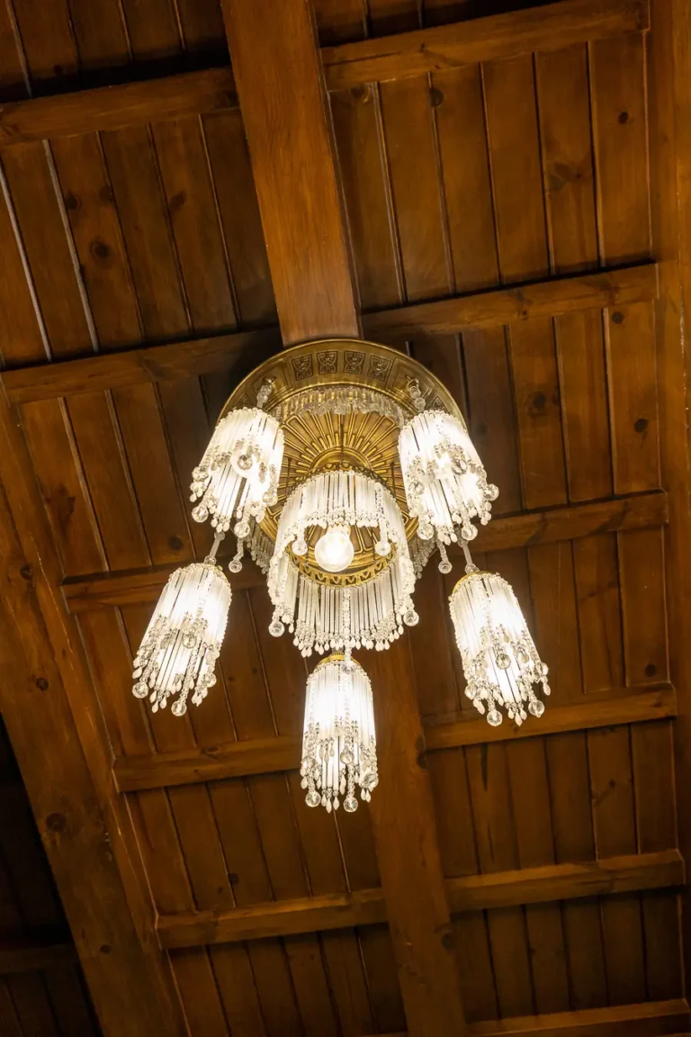 lampara de cristal colgante bajo techo de vigas de madera