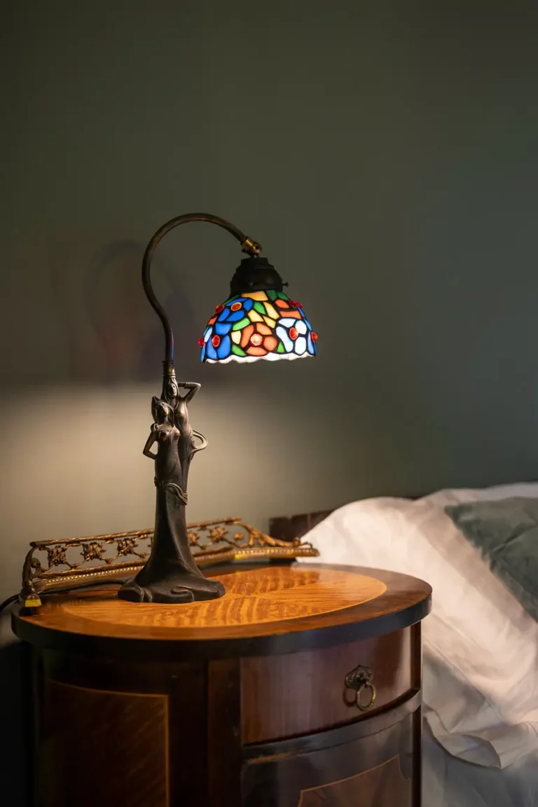 lampara de vidrieras de colores sobre mesita de noche de madera