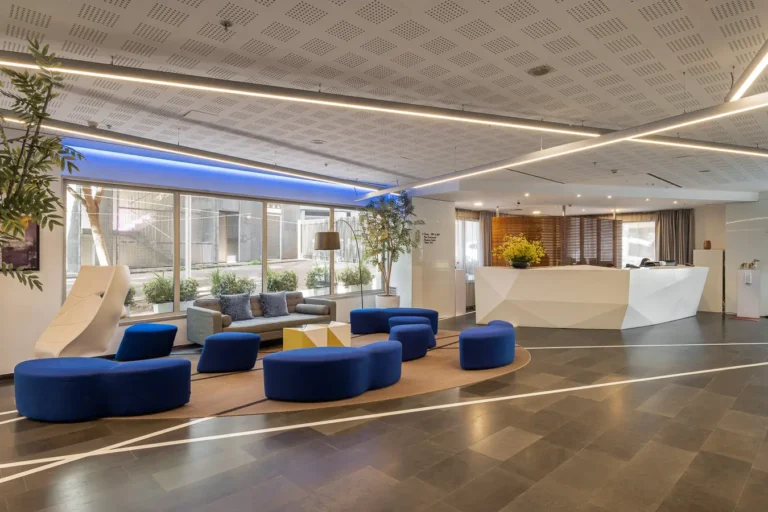 lobby de hotel moderno con recepcion y asientos azules