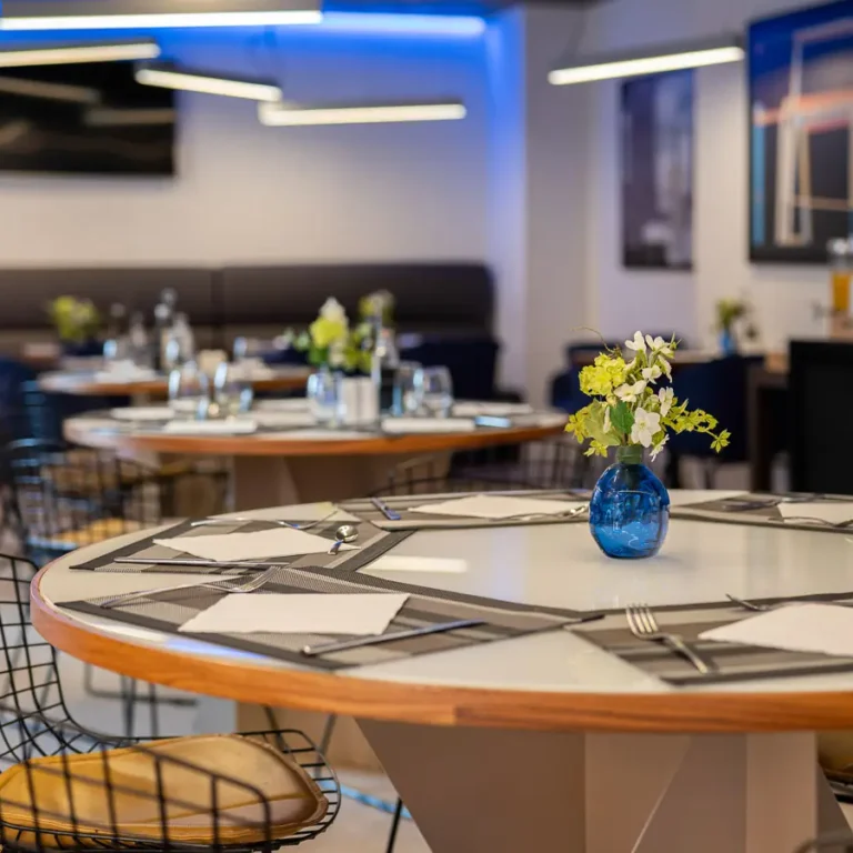 mesa del restaurante con florero azul y servicio