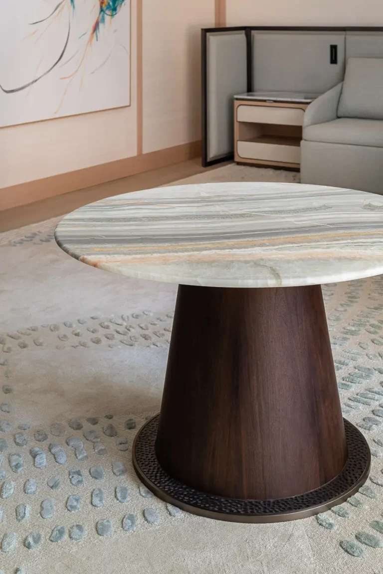 mesa redonda de piedra con base de madera en habitacion de hotel