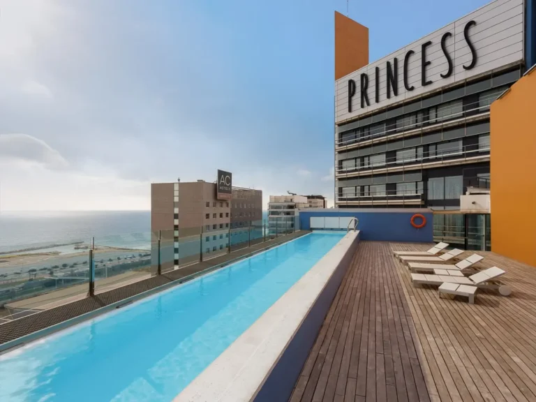 piscina en azotea hotel con vistas al mar y tumbonas