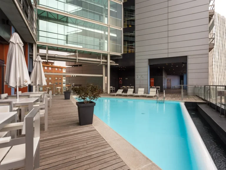 piscina hotel en terraza con tumbonas y zona de descanso