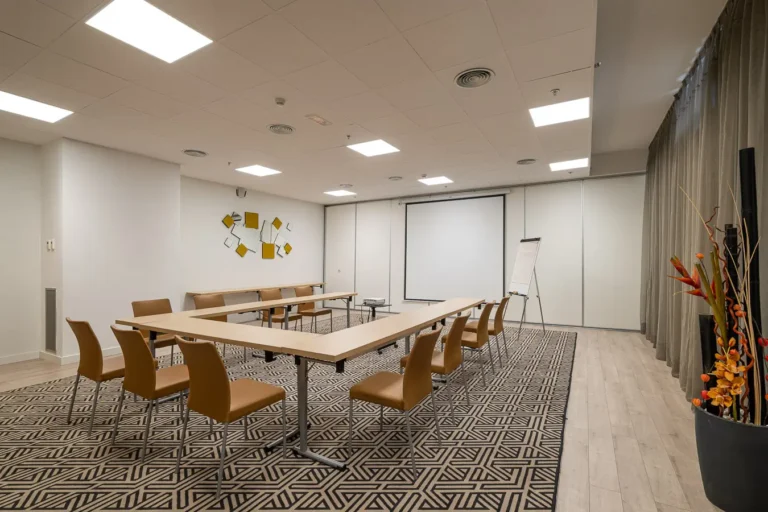 sala de conferencias de hotel con mesas en forma de u