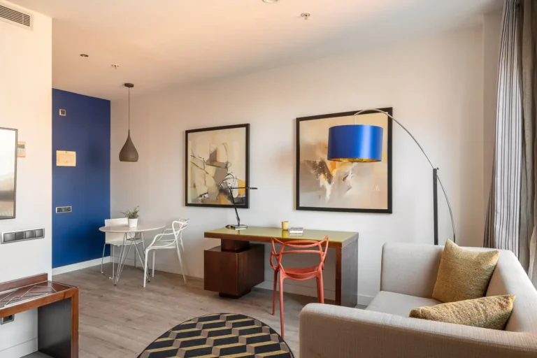salon de hotel con escritorio comedor y sofa claro