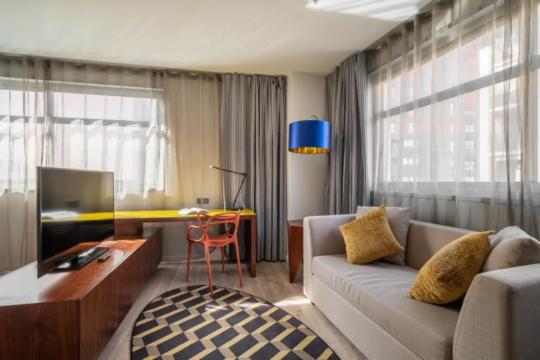 salon de suite de hotel con sofa escritorio y televisor