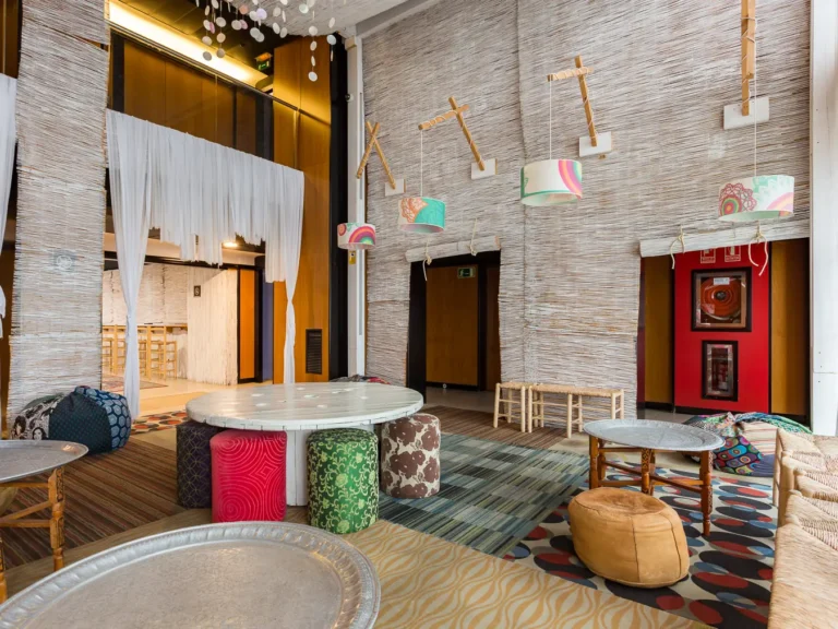 salon hotel decorado con pufs mesas bajas y lamparas estampadas