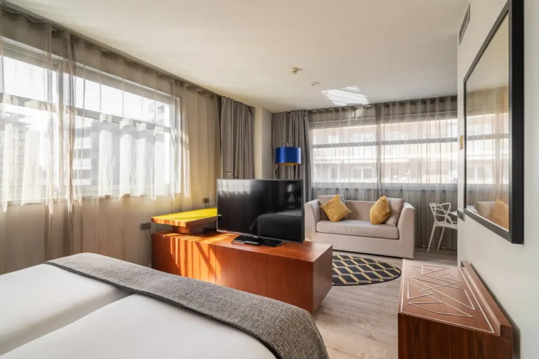 suite de hotel con dormitorio salon y grandes ventanales