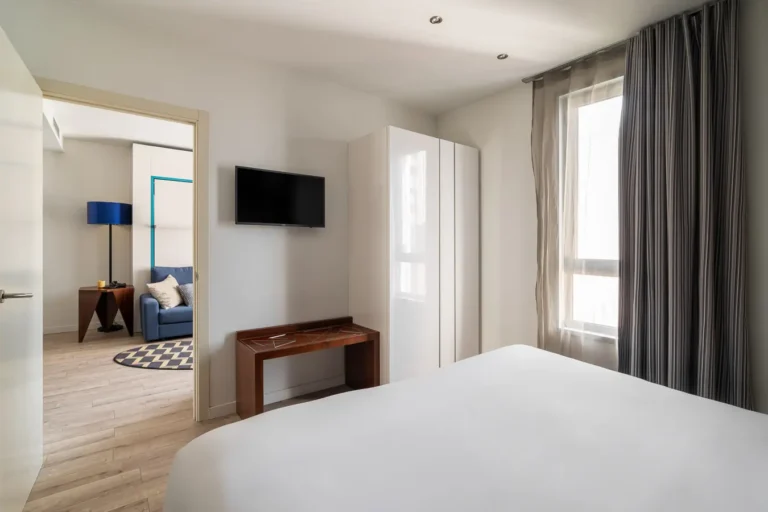 suite de hotel con dormitorio televisor y salon