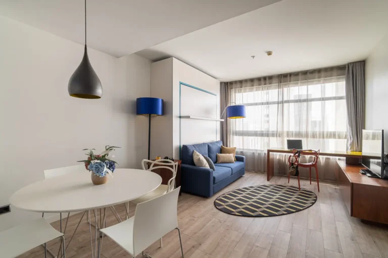 suite de hotel con salon comedor y sofa azul