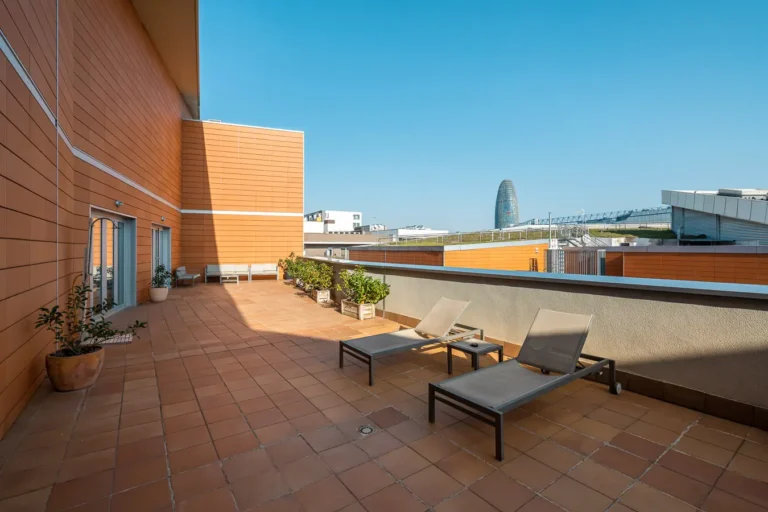 terraza de hotel con tumbonas y vistas urbanas