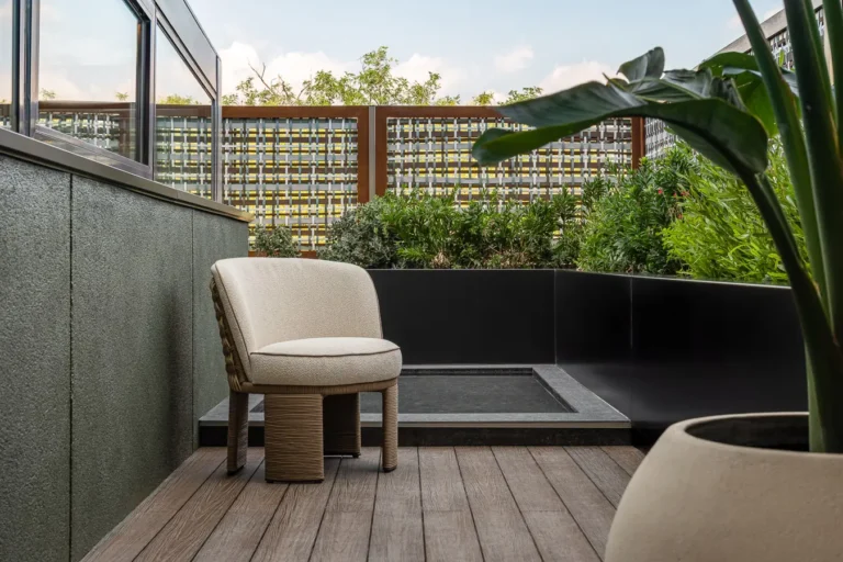 terraza privada de hotel con sillon y jardineras