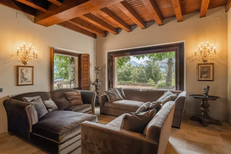 zona de descanso con sofas de terciopelo y ventanales al bosque